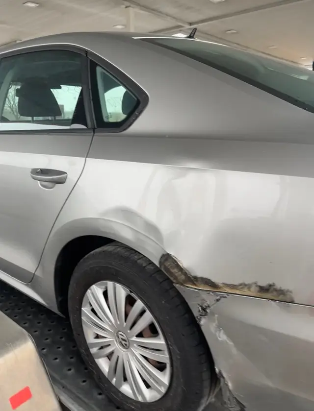 Silver sedan with a scraped rear door and quarter panel